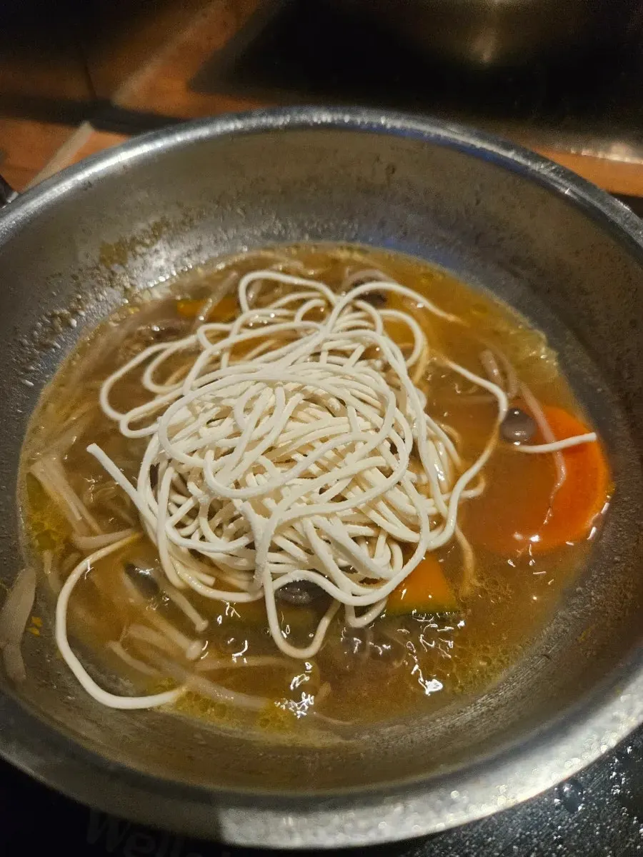 Kalguksu noodles added to rich broth