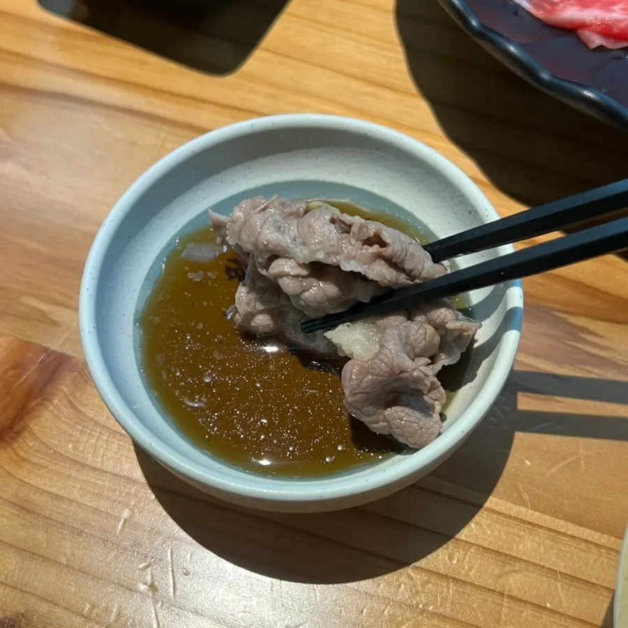 간장 소스에 찍은 샤브샤브 고기