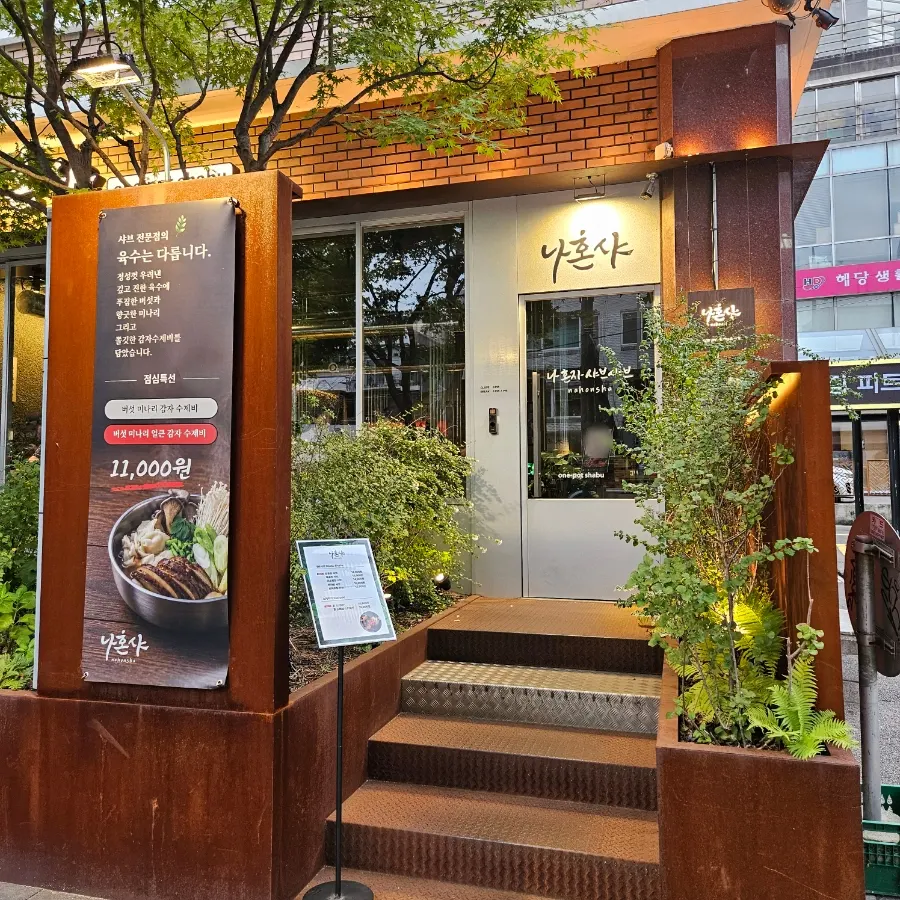 우드톤 외벽과 식물로 꾸며진 나혼샤 외관