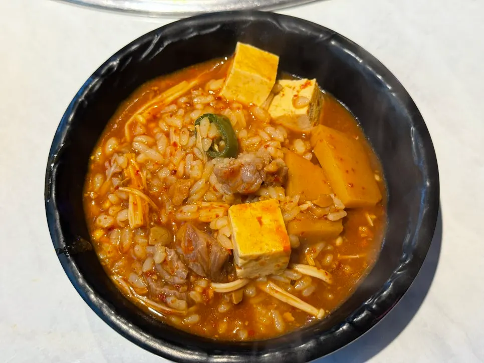 A spoonful of doenjang rice soup packed with ingredients