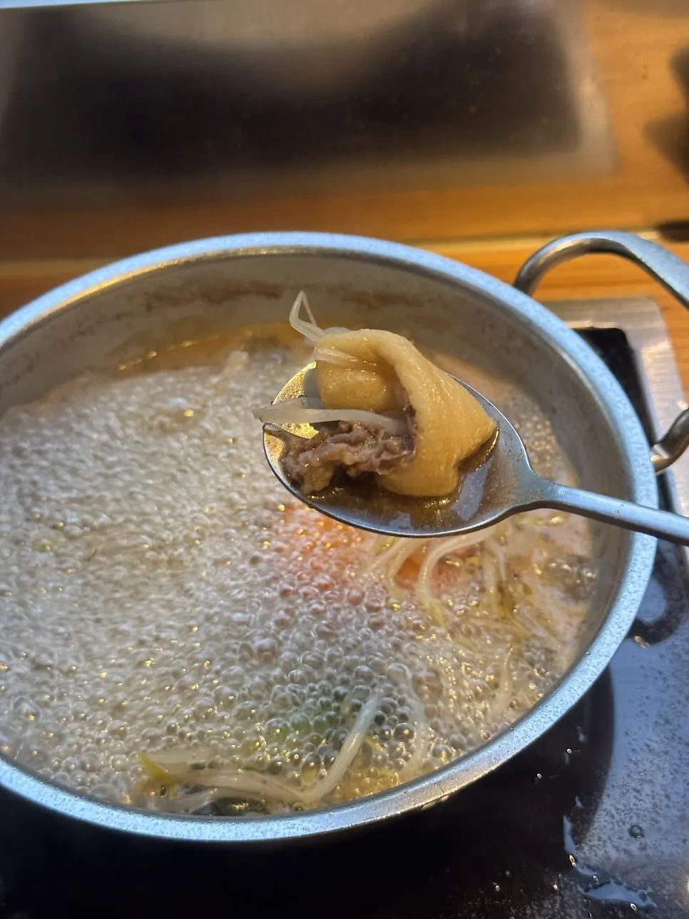 Solo pot of clear broth simmering with meat