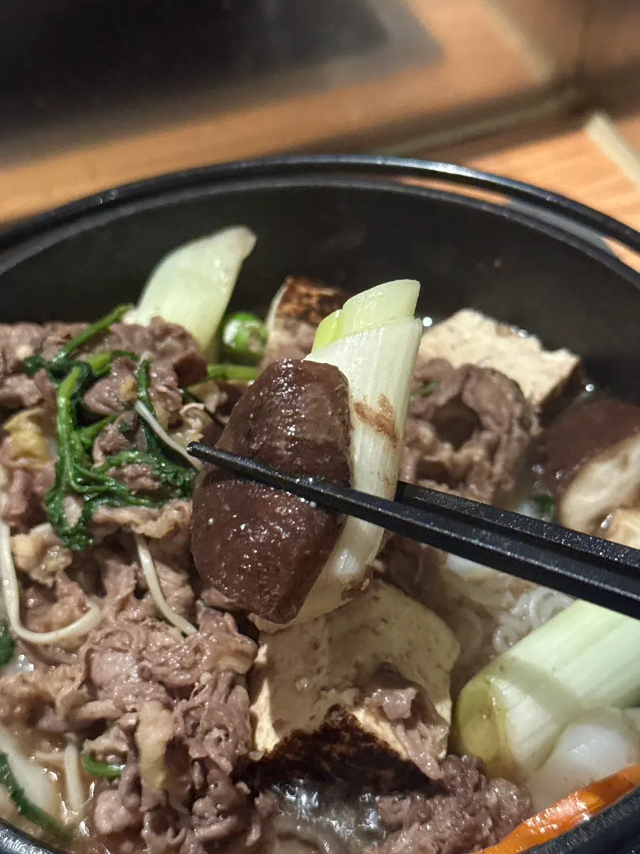 Cooked sukiyaki meat dipped in sauce