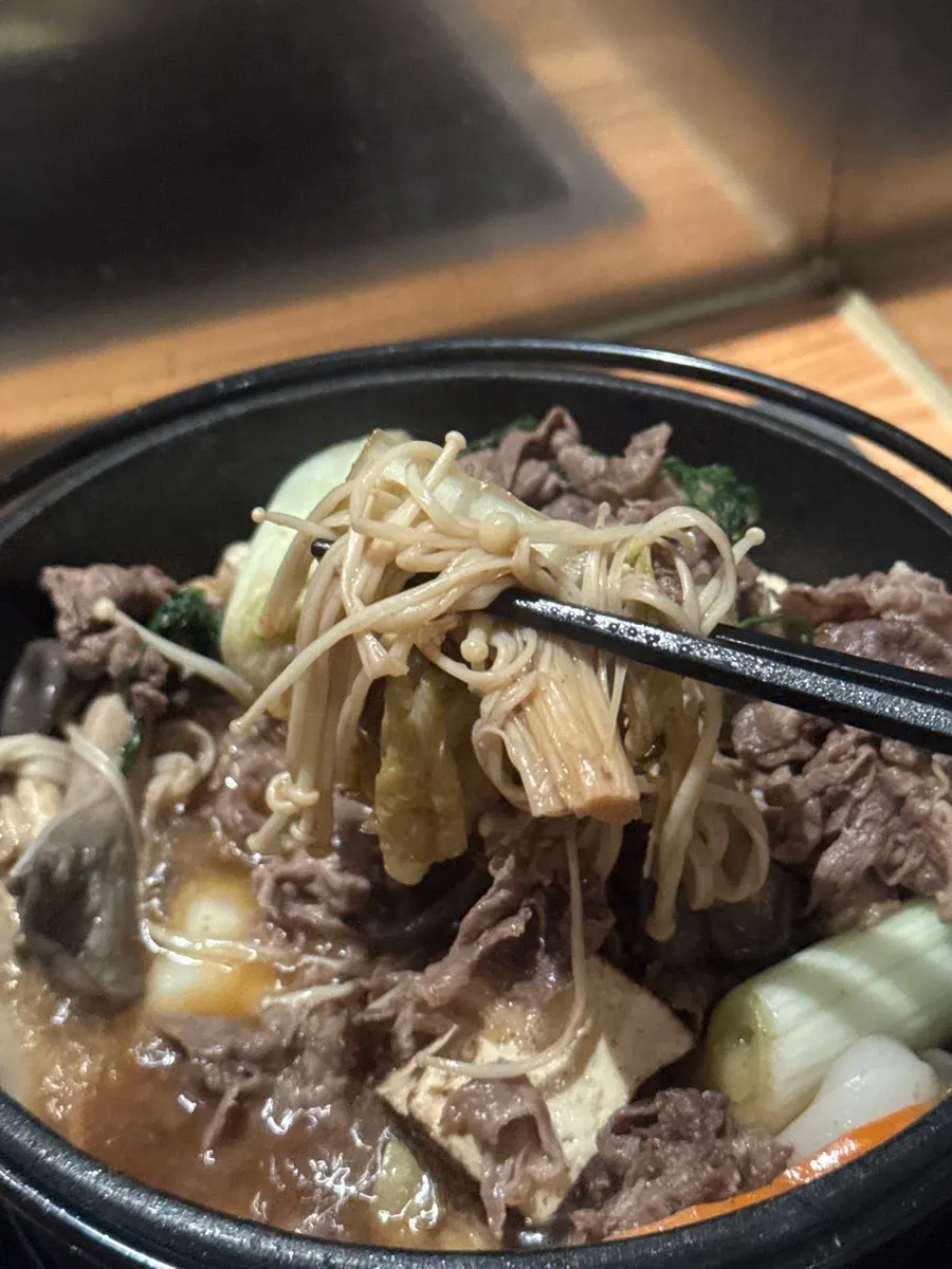 Sukiyaki meat lifted with chopsticks