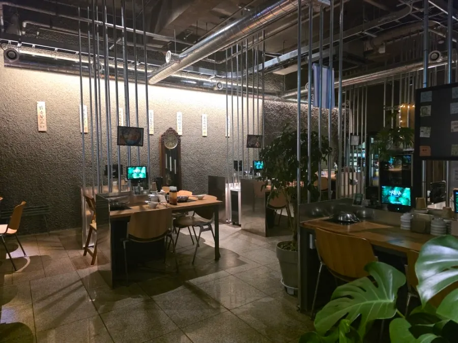 Nahonsha's interior with wood-toned tables and plants