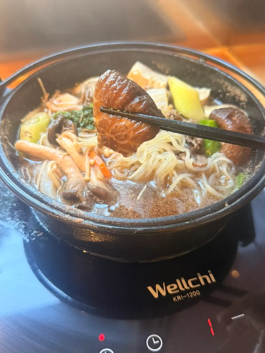 Sukiyaki broth ladled out of the pot