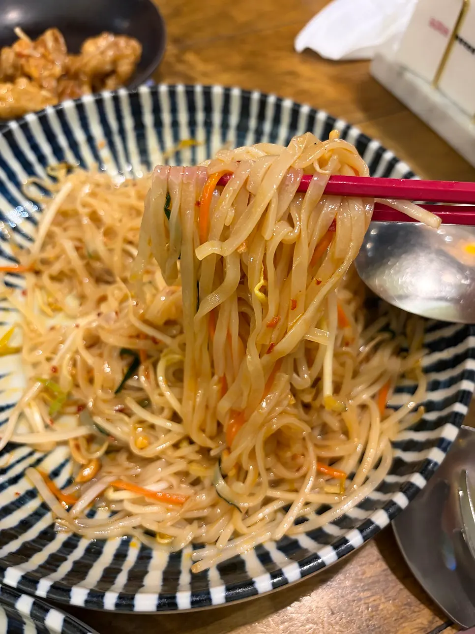 Lifting up a bite of pad thai noodles
