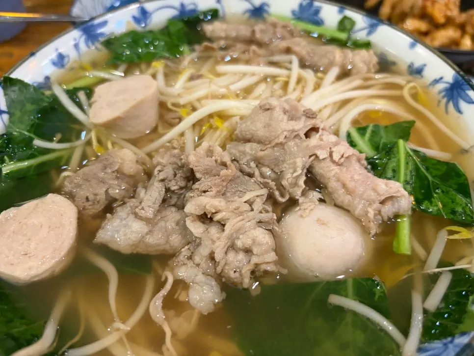 A bowl of Thai rice noodle soup topped with bean sprouts