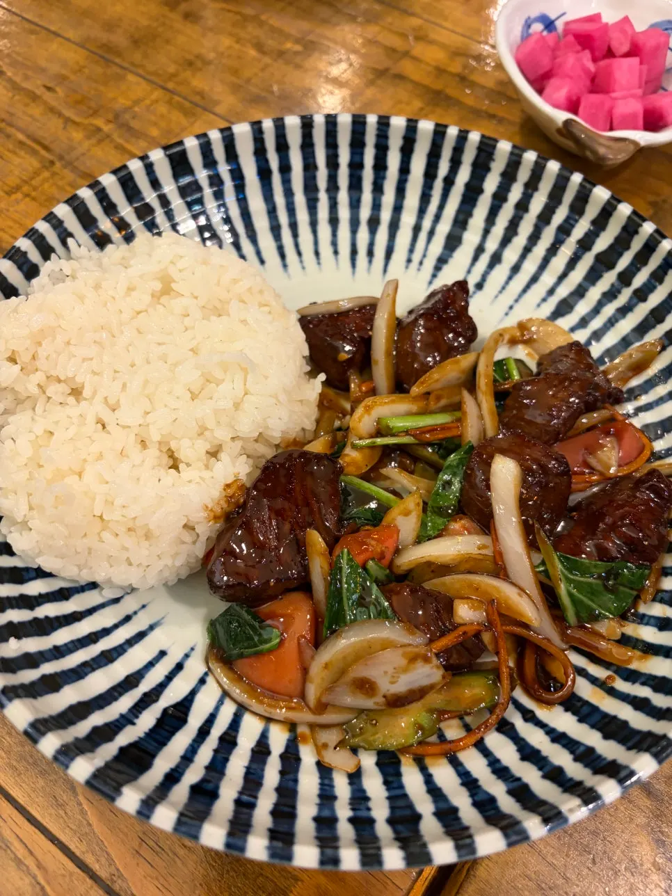 Close-up of the rice bowl topped with large pieces of beef