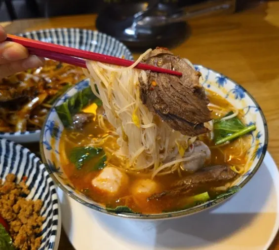 Close-up of tom yum rice noodle soup noodles and meat