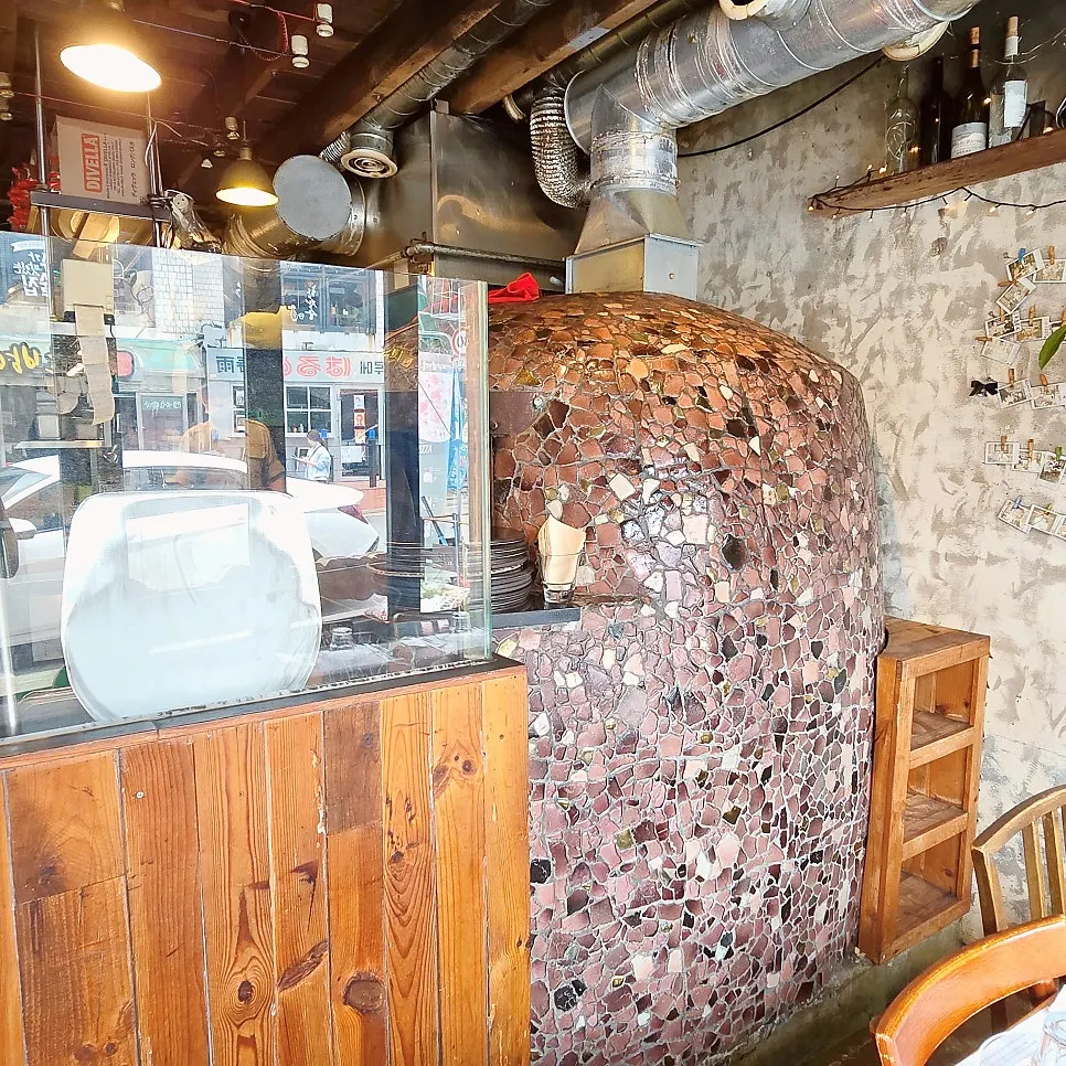 Wall decorated with photos at Hongdae Hwadeok Pizza
