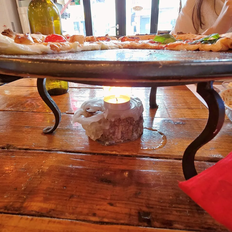 A slice of wood-fired pizza with stretching cheese