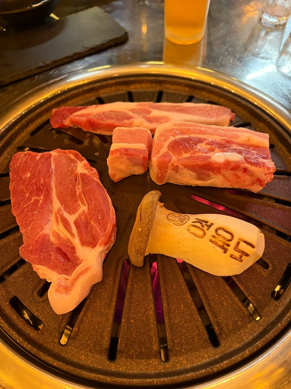 Thick pork belly grilling over the charcoal grill
