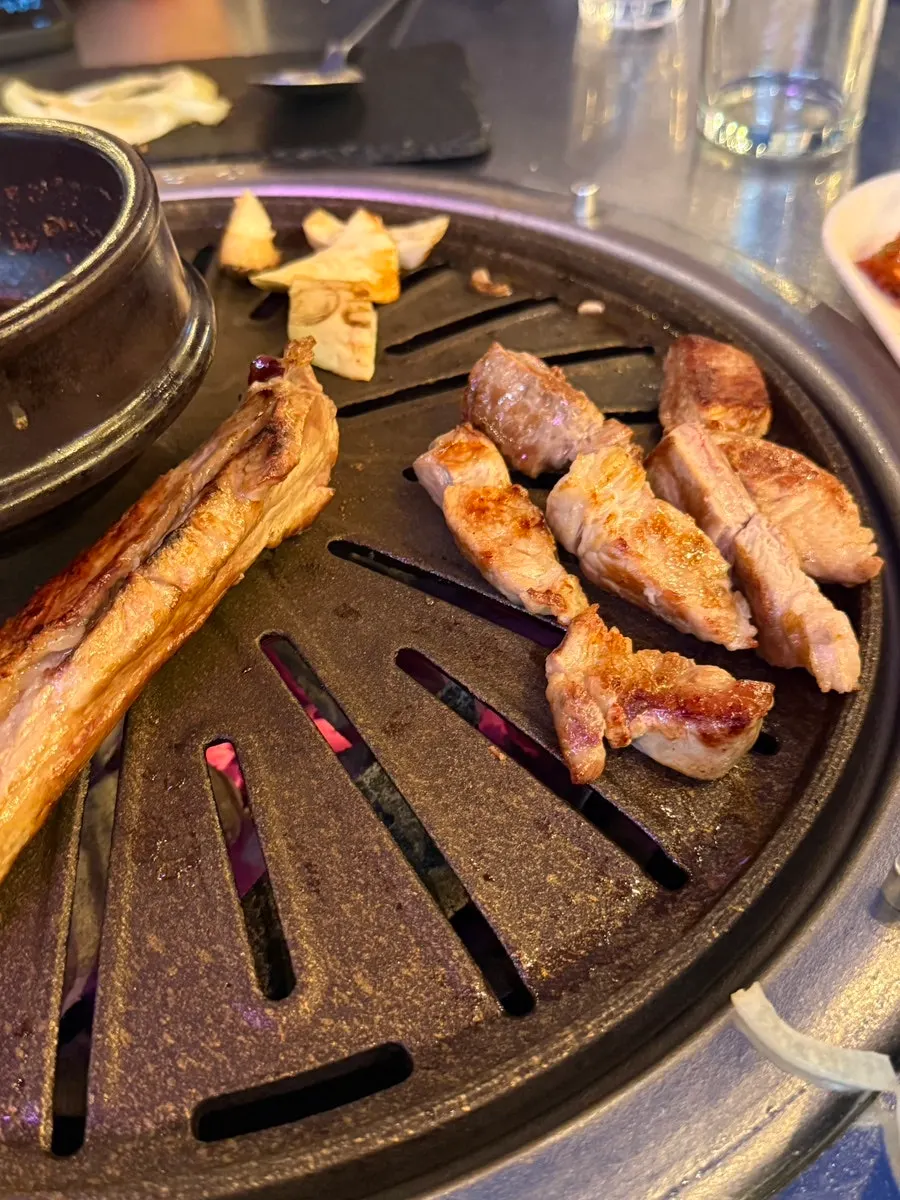 야장 불판에서 피어오르는 고기 연기