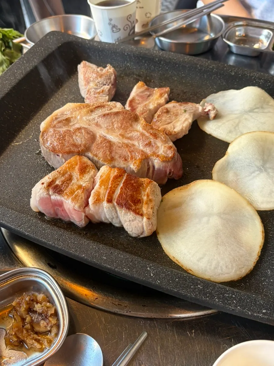 Staff member grilling thick cuts of meat