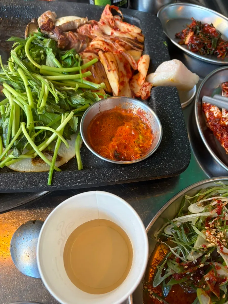 Meat and kimchi arranged side by side on the grill