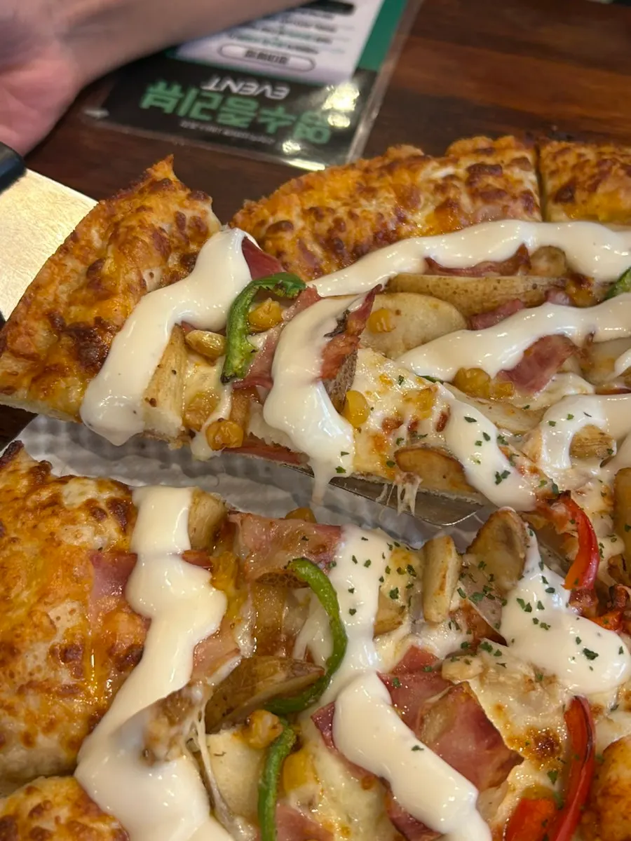 A slice of tongtong shrimp pizza with generous chili sauce