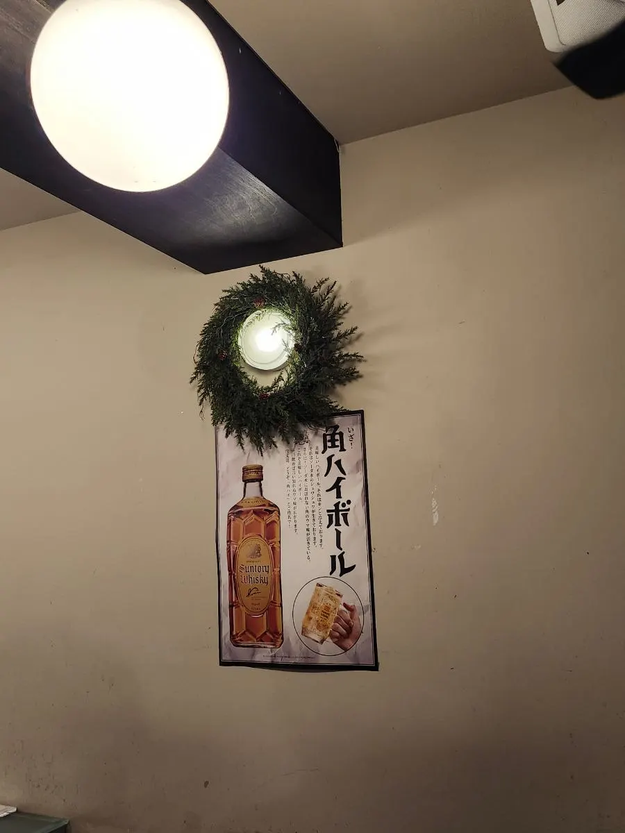 控えめな丸い照明が灯る居酒屋の席