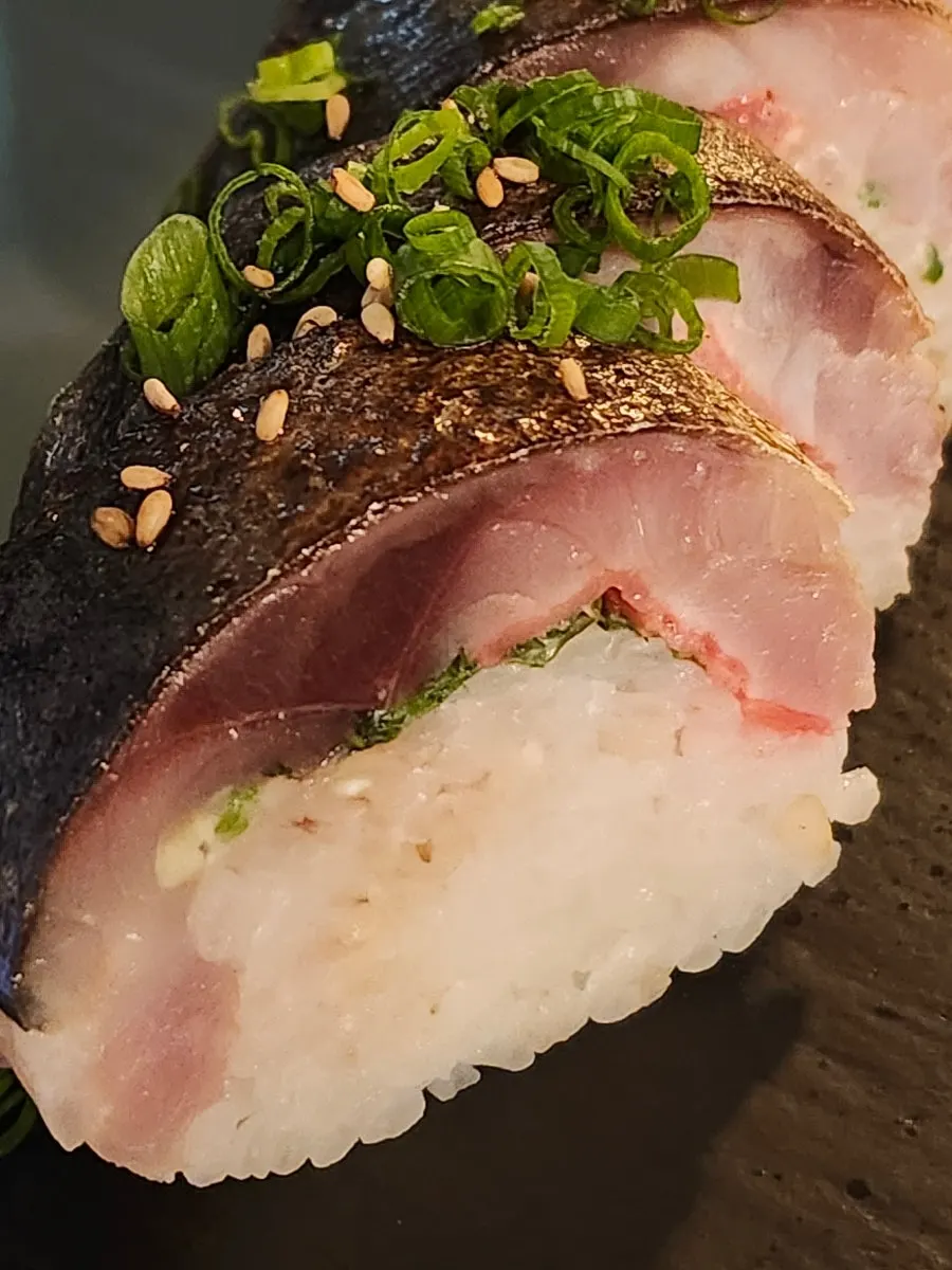 海苔で巻いて醤油につけたサバ棒寿司