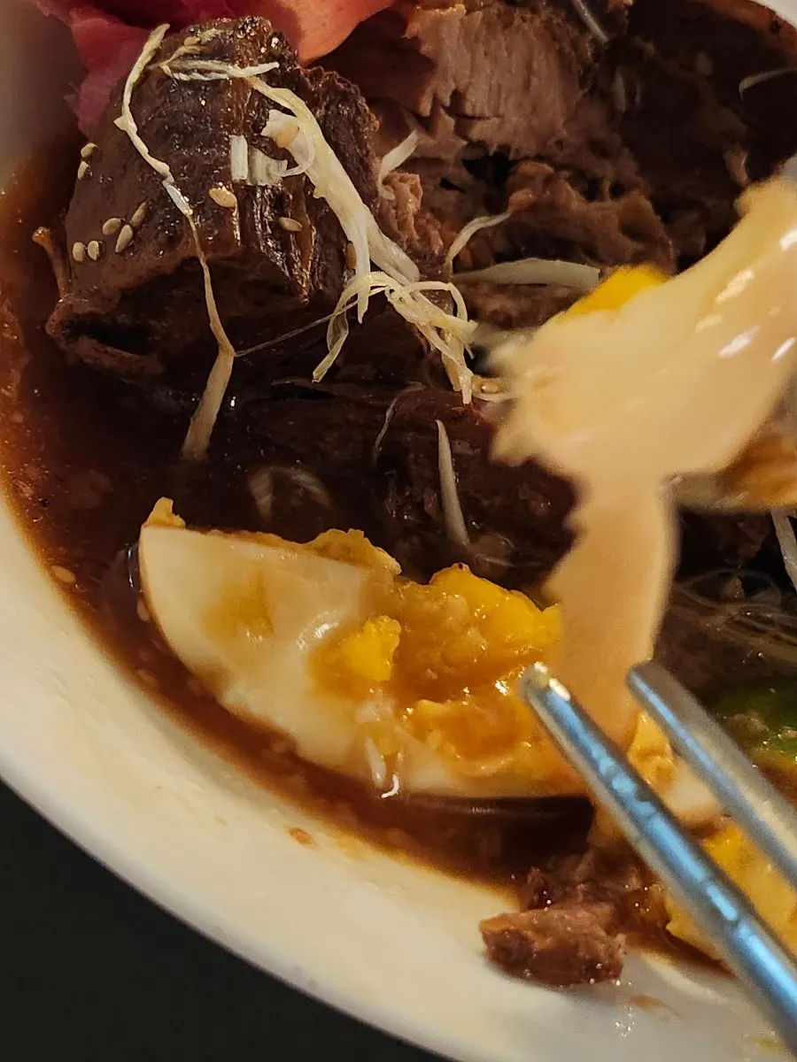 東坡肉を一切れつまみ上げた様子