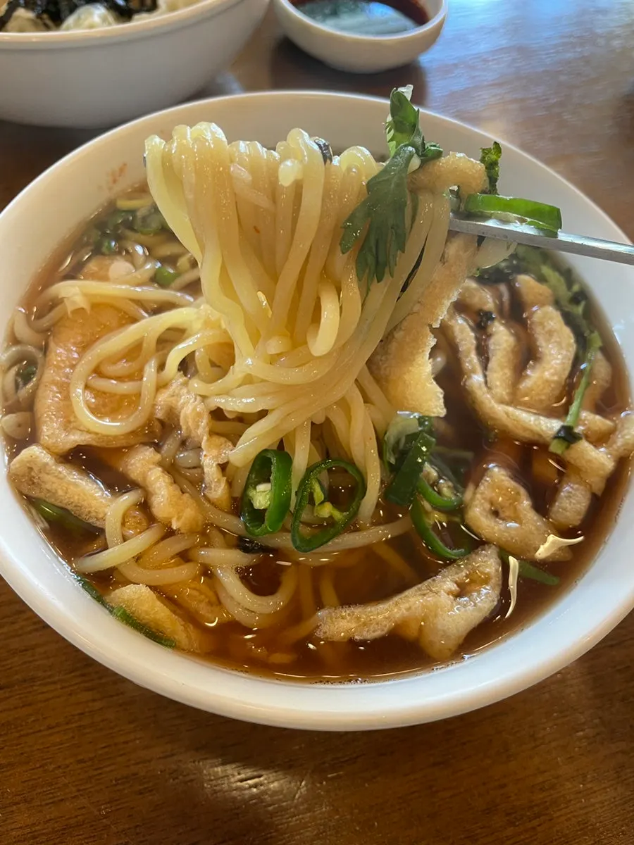 Old-style yellow noodles lifted out of the spicy udon