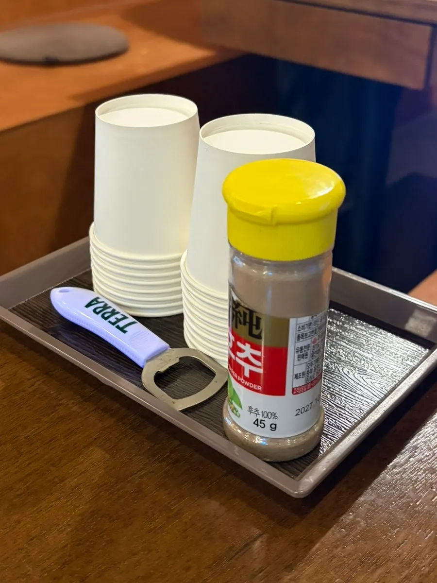 Table with paper cups and pepper