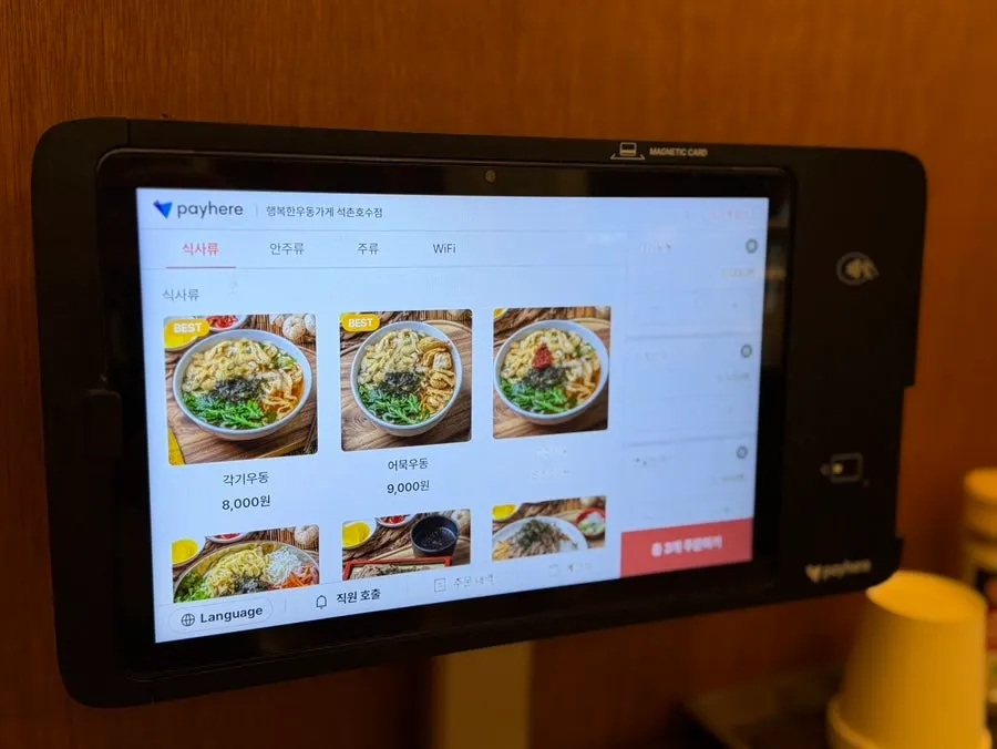 Menu board listing udon, pork cutlet, and rice bowls