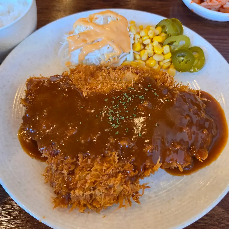 Old-style pork cutlet topped with brown sauce, served with cabbage salad