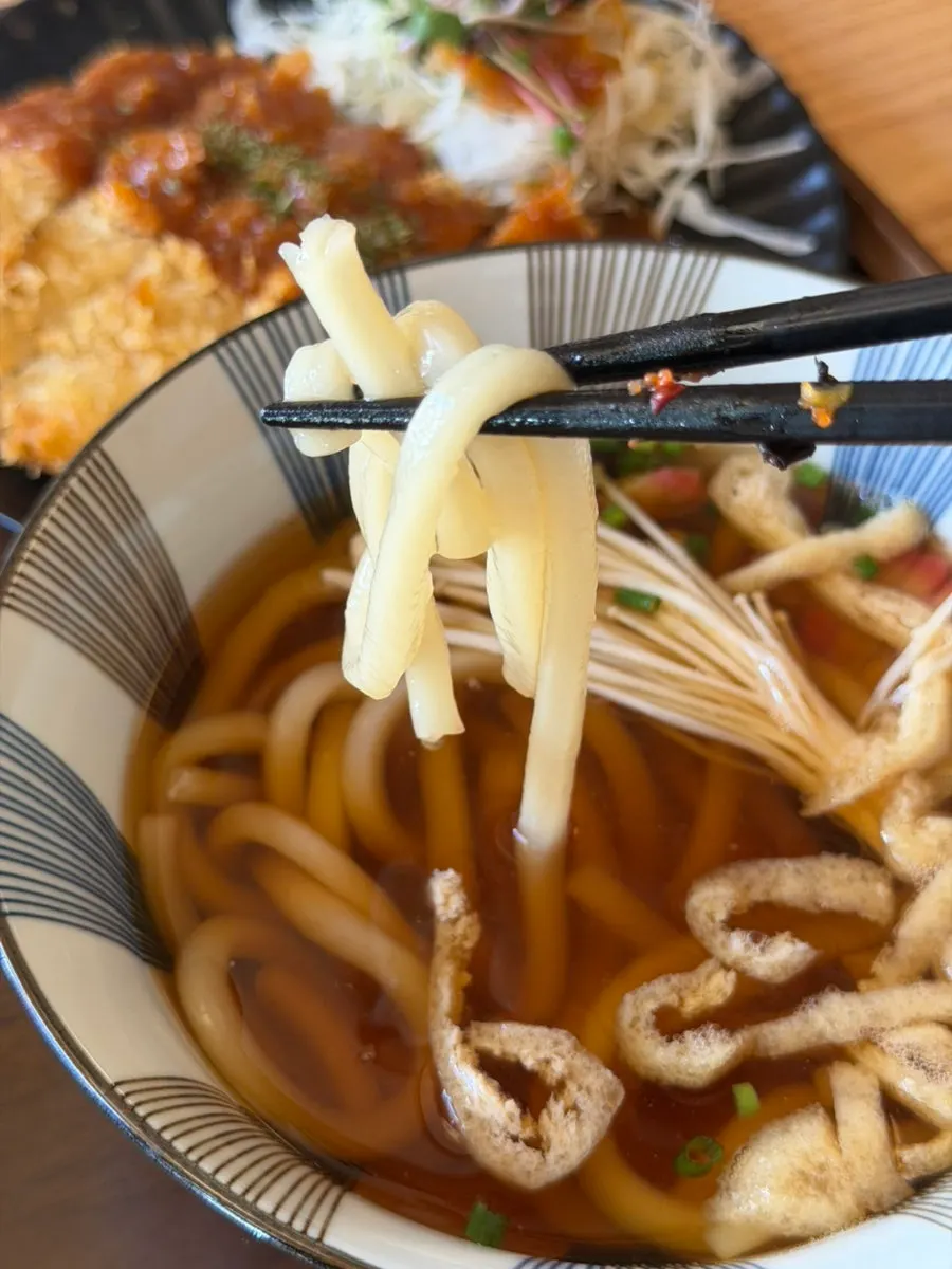 Udon topped with fish cake, naruto, and enoki mushrooms
