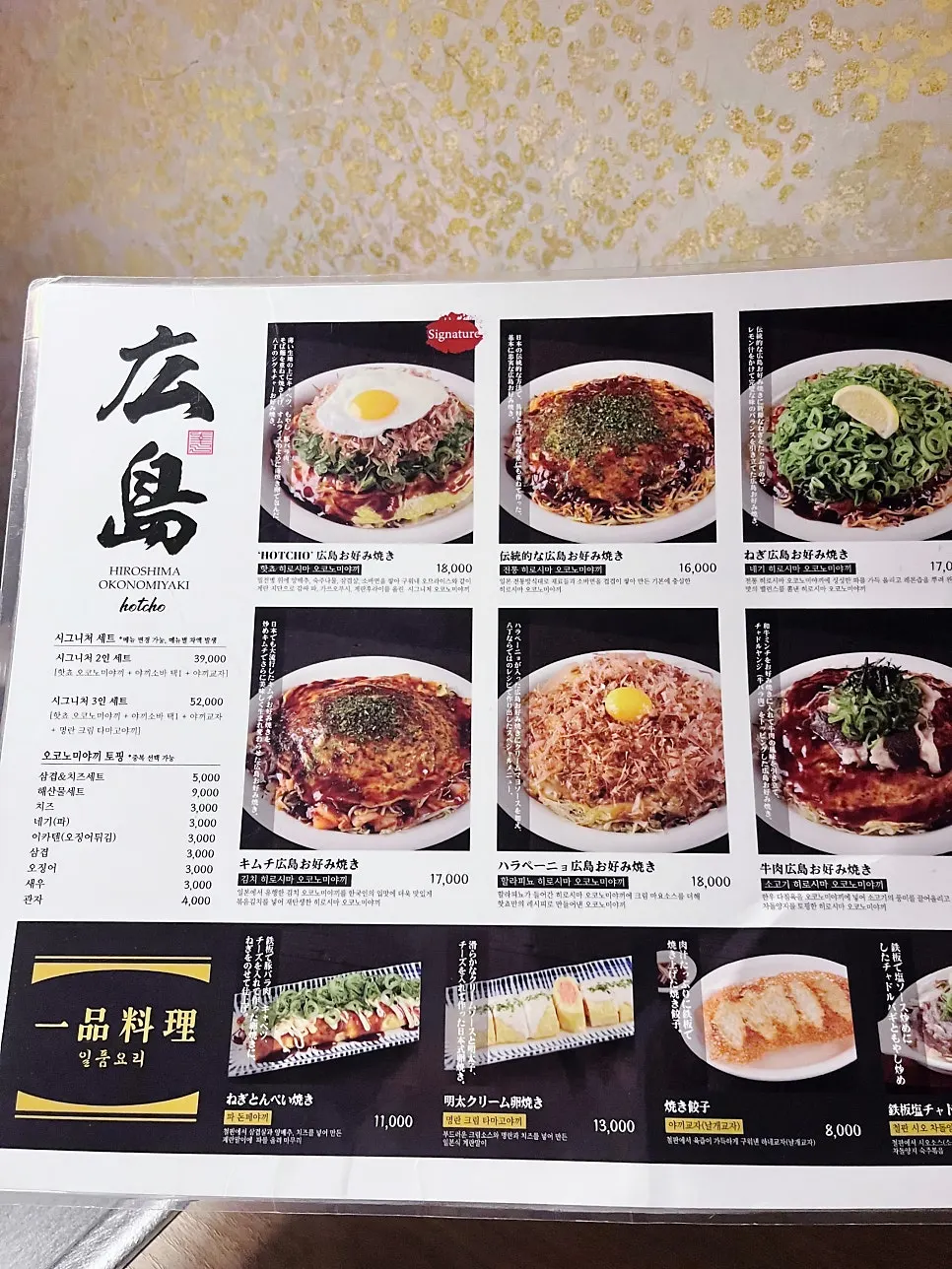 Hiroshima-style okonomiyaki nearing completion on the teppan