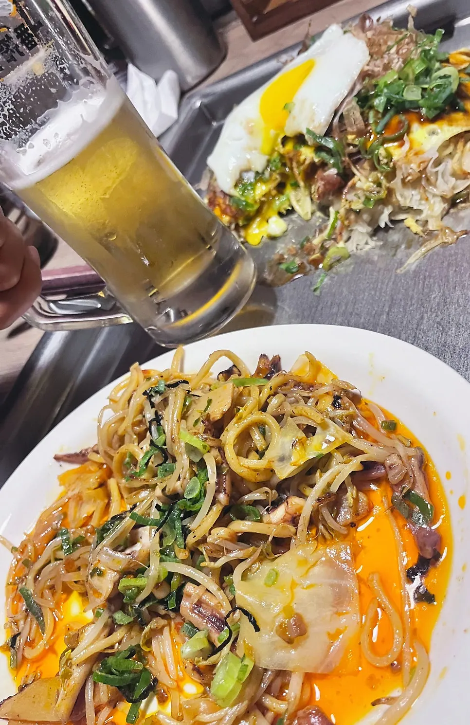 Cold draft beer served alongside the yakisoba
