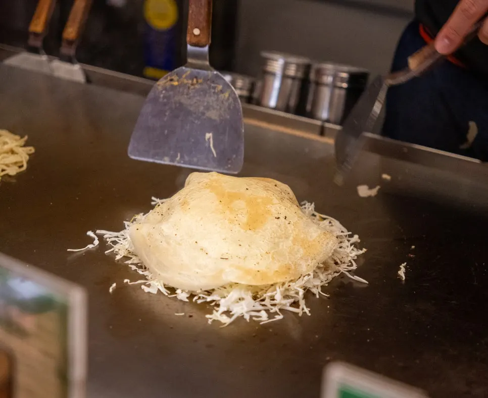 Okonomiyaki kiểu Hiroshima đang chín trên chảo sắt