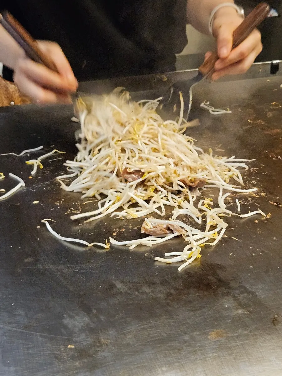 철판에서 오꼬노미야끼를 빠르게 굽는 모습