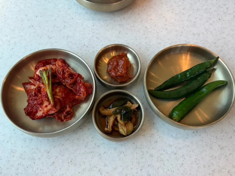 Side dish spread of kimchi, mu-jangajji, and peppers