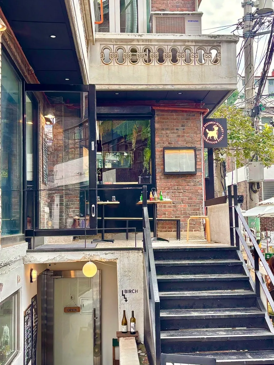 해방촌 골목 초입 더피제리아마켓 외관과 테라스석