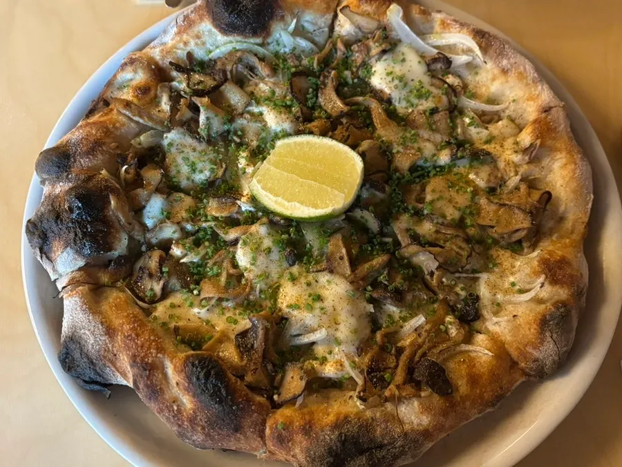 Freshly made fall mushroom and smoked mozzarella pizza