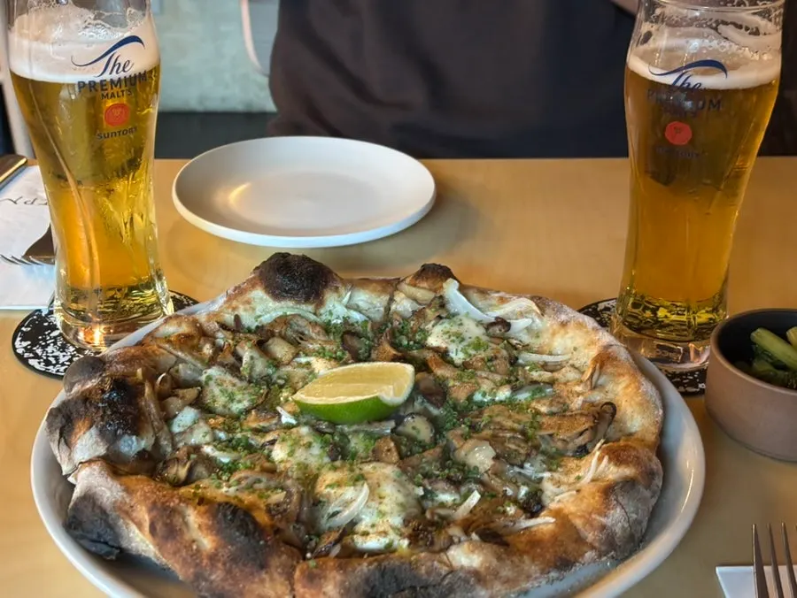 A whole wood-fired pizza piled high with vegetables