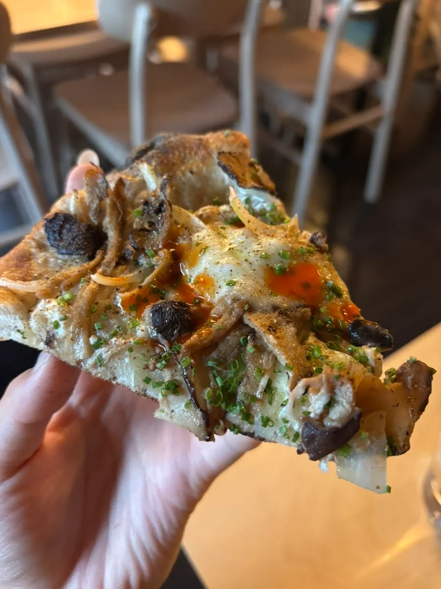 Close-up of a pizza slice packed with mushrooms and cheese
