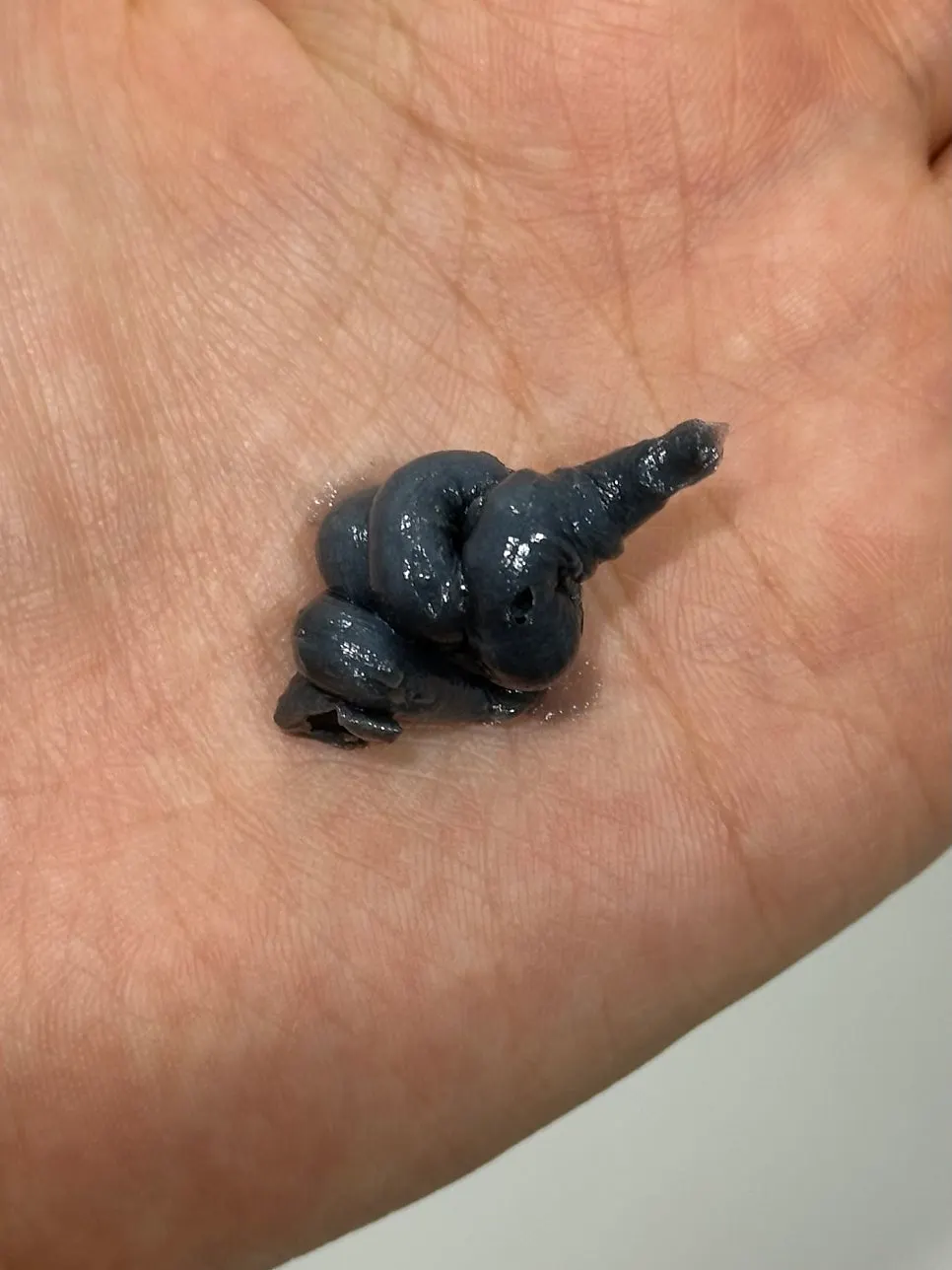 Black charcoal cleansing foam contents dispensed onto hand