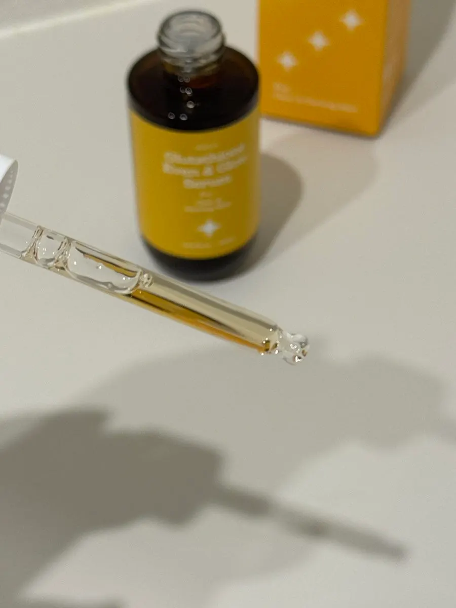 Holding the whitening serum with the dropper cap open