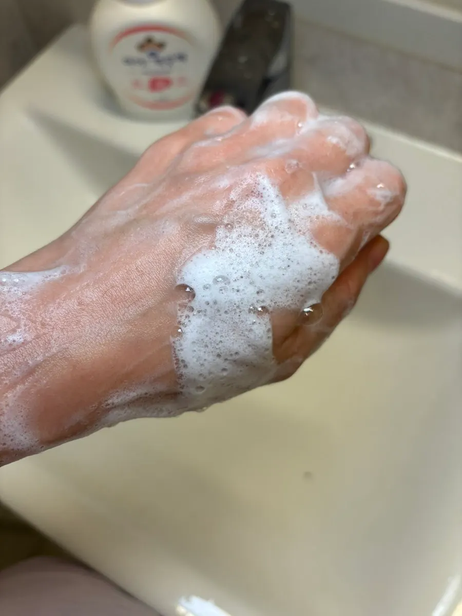 Rich white foam building up on the back of a hand