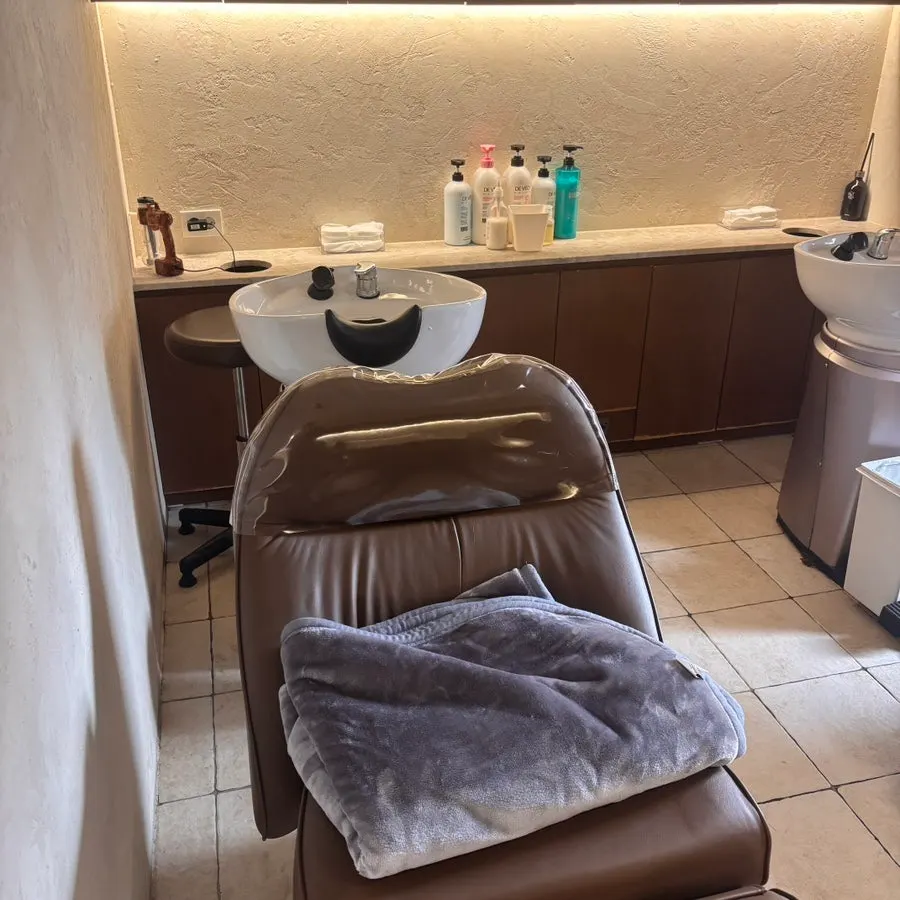 Lying under a blanket during shampoo time at Heeol Hair