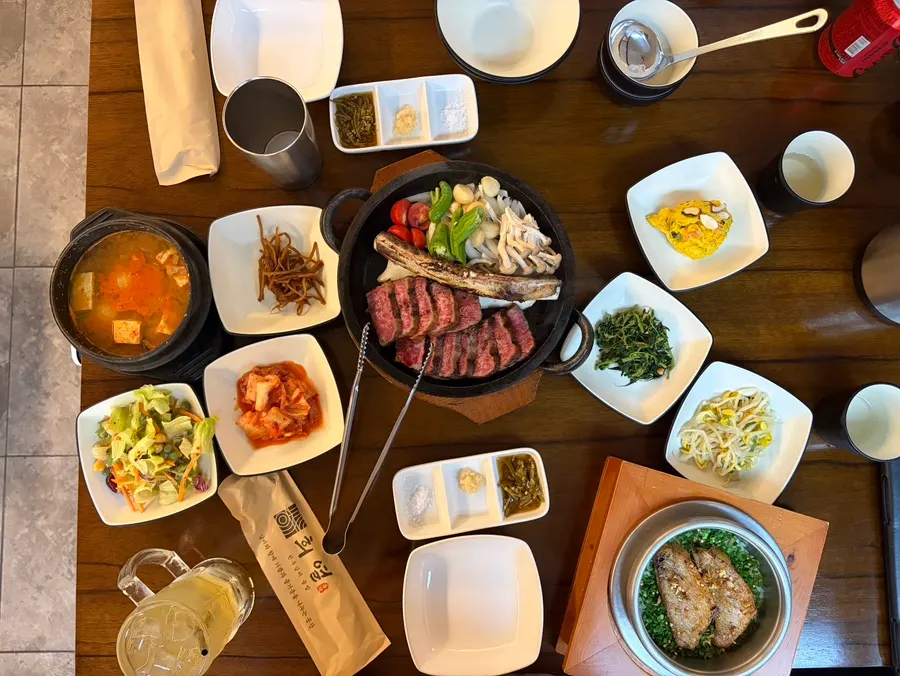 Korean side dish spread with bean sprouts, seasoned greens, and salad
