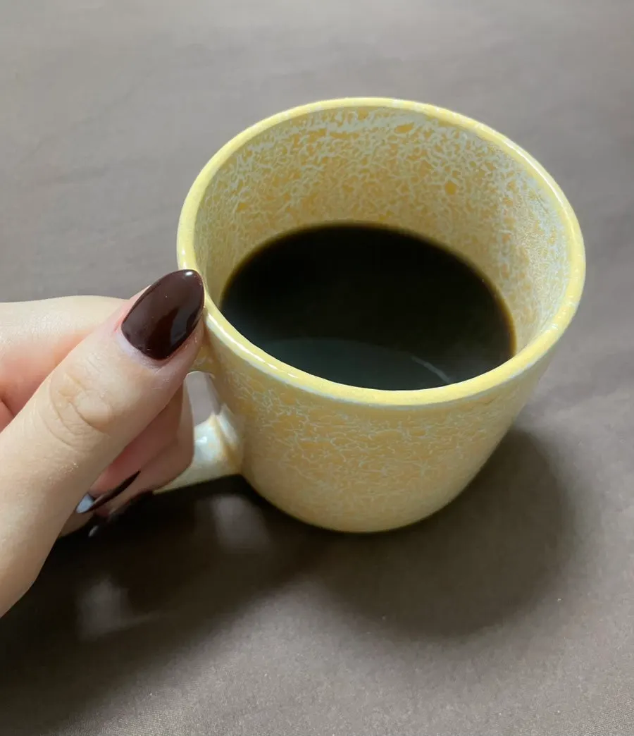 Diet coffee mixed with hot water served alongside cake