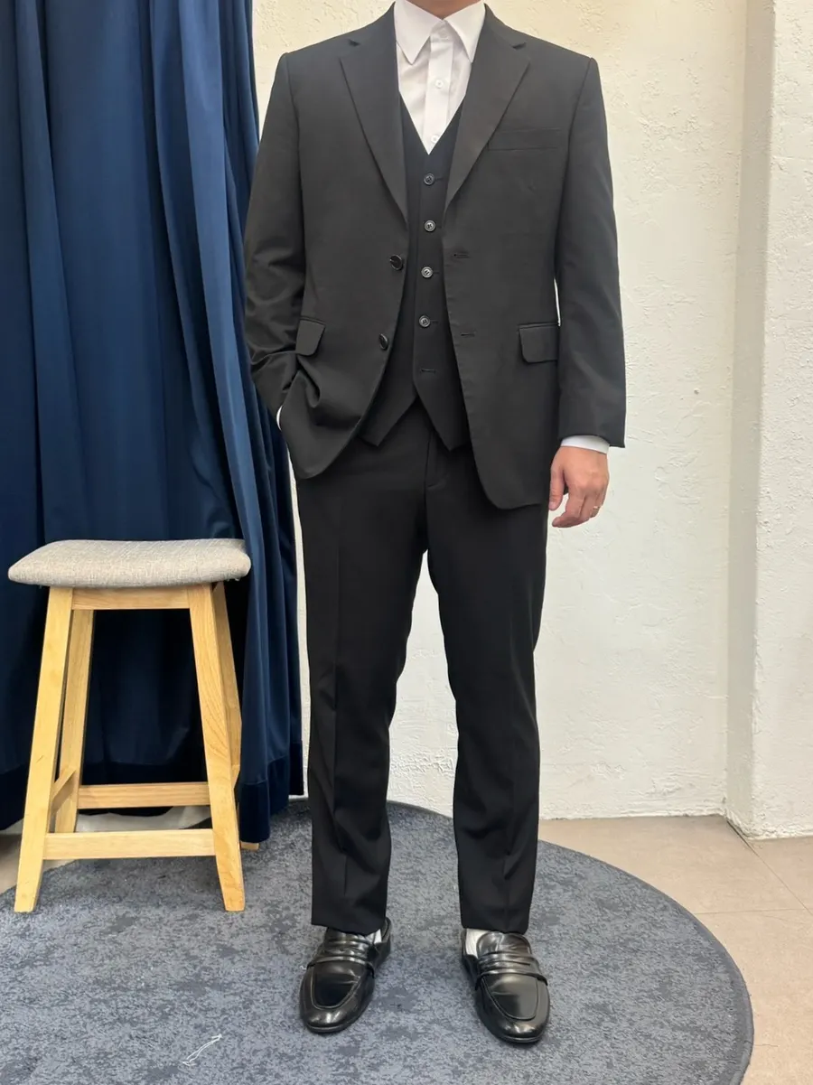 Black shoot suit tried on with a vest