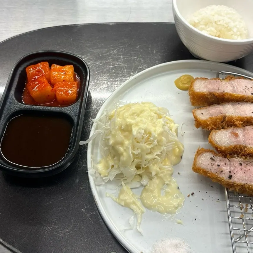 Pepper being sprinkled onto the tonkatsu