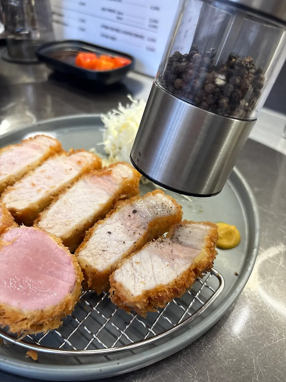 A piece of katsu sprinkled with black pepper
