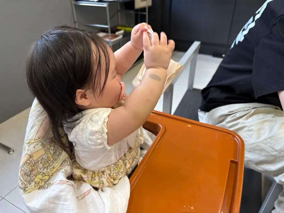 Baby seated in the baby chair at the table