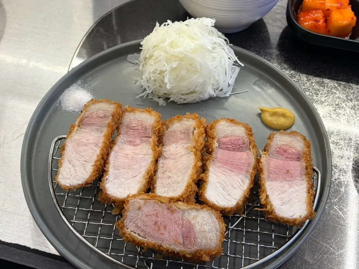 Cross-section of Jeju black pork katsu showing pink flesh