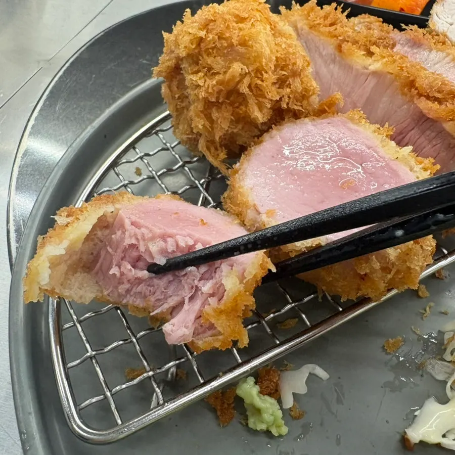 A piece of hire katsu held with chopsticks