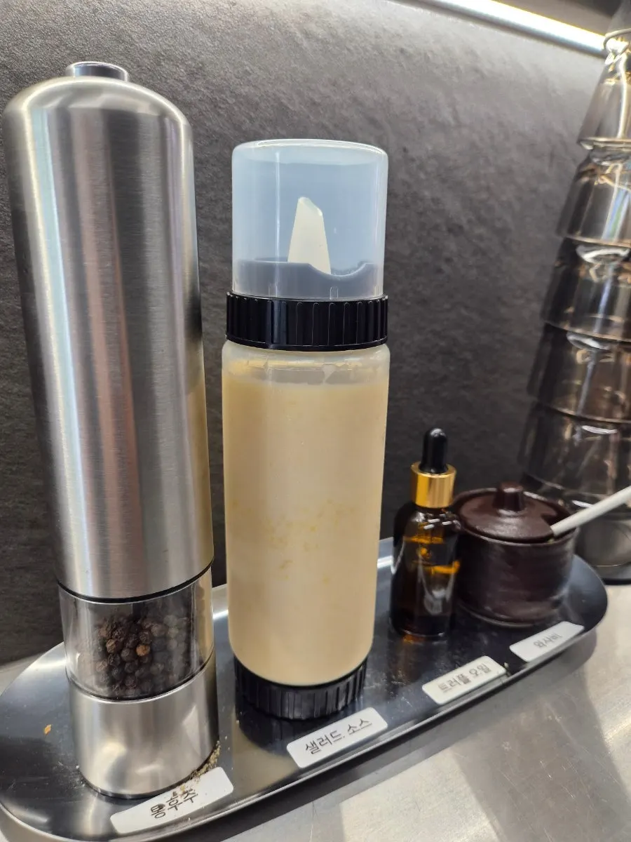 Sauce containers with whole pepper, salad sauce, truffle oil and wasabi